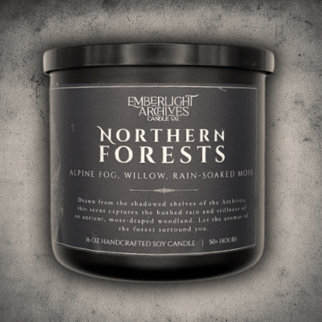Emberlight Archives Northern Forests candle in a 16oz black glass jar with dark label against a gray stone background, Rain & Moss scent.